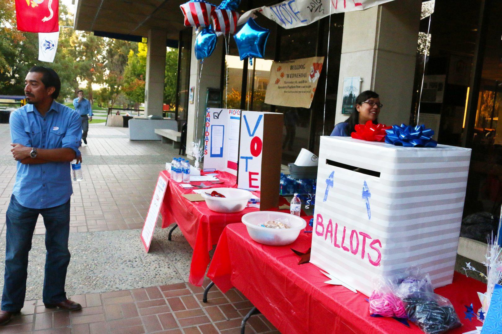 Rico Franco, left, stands at a ballot drop-off site located on the University Student Union balcony at Fresno State. Franco previously ran for Congress House District 22. (Cresencio Rodriguez-Delgado/The Collegian)