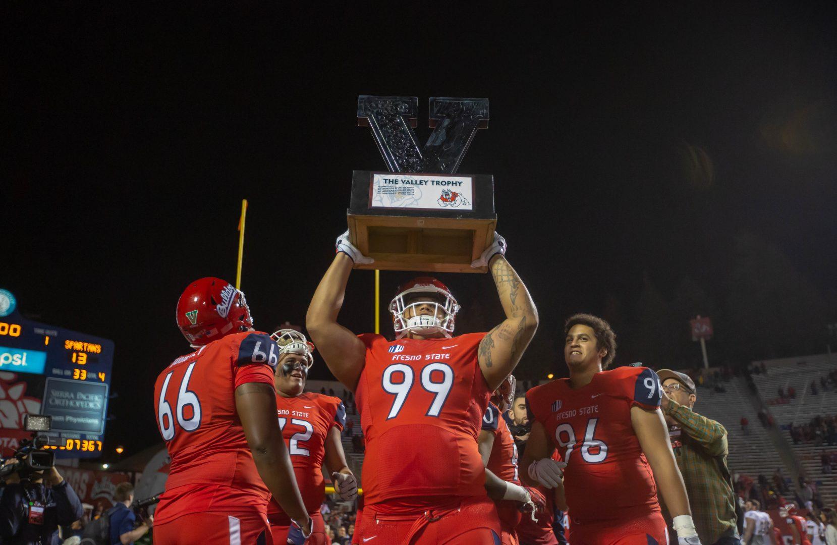 Fresno State defensive linemen Ricky McCoy lifts the Valley Trophy following the Bulldogs’ 31-13 victory over San Jose State on Nov. 24, 2018. (Jose Romo/ The Collegian)