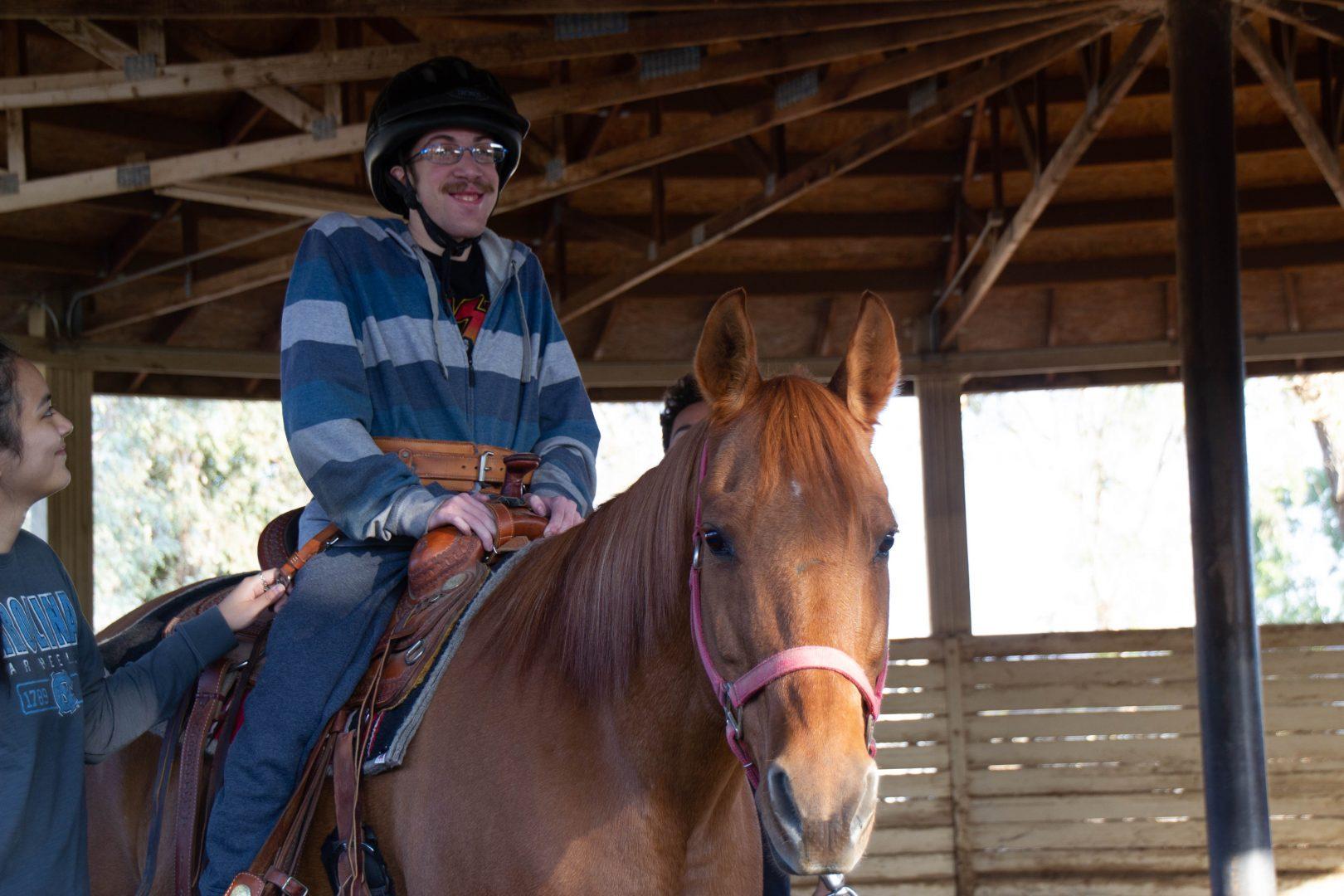 Michael McFadden, who was diagnosed with several illnesses as a child, rides a horse at the Heart of the Horse Therapy Ranch on Nov. 4. (Cassie Richter/The Collegian)