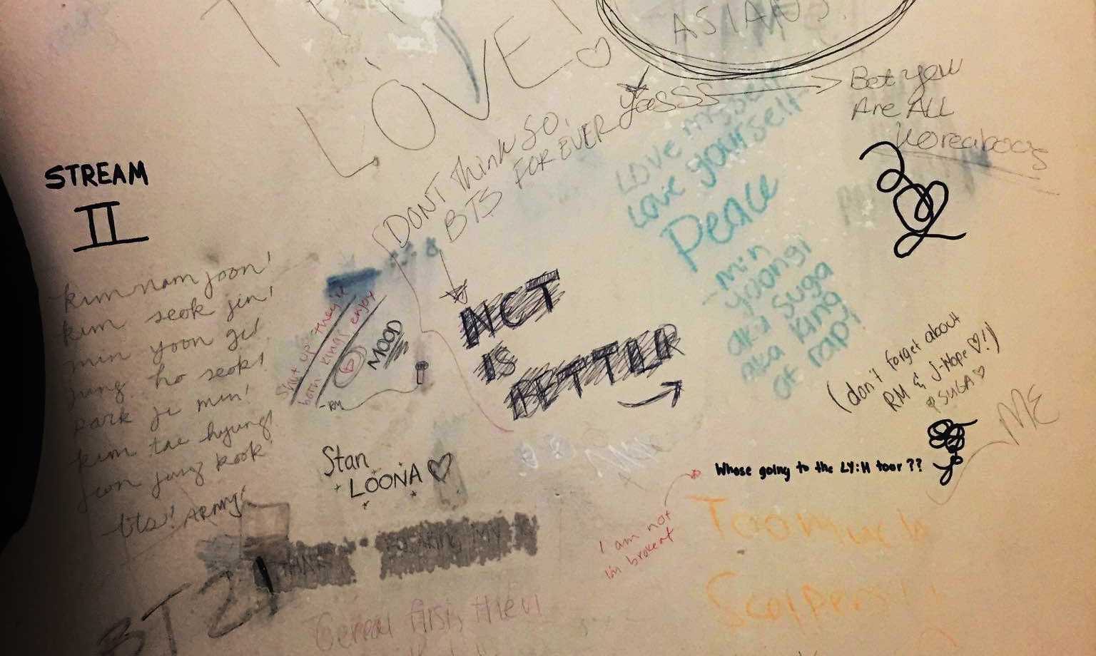 An argument over K-pop breaks out on a bathroom stall at Fresno State. (Samantha Domingo/The Collegian)
