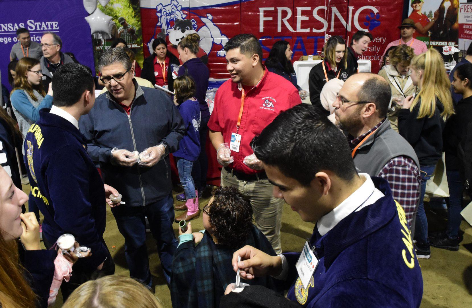 Fresno State president Dr. Joseph I. Castro and ag ambassador Omar Hernandez hand out Fresno State ice cream at the World Ag Expo in Tulare on Feb. 14, 2019. (Geoff Thurner/ Jordan College of Agricultural Sciences and Technology)