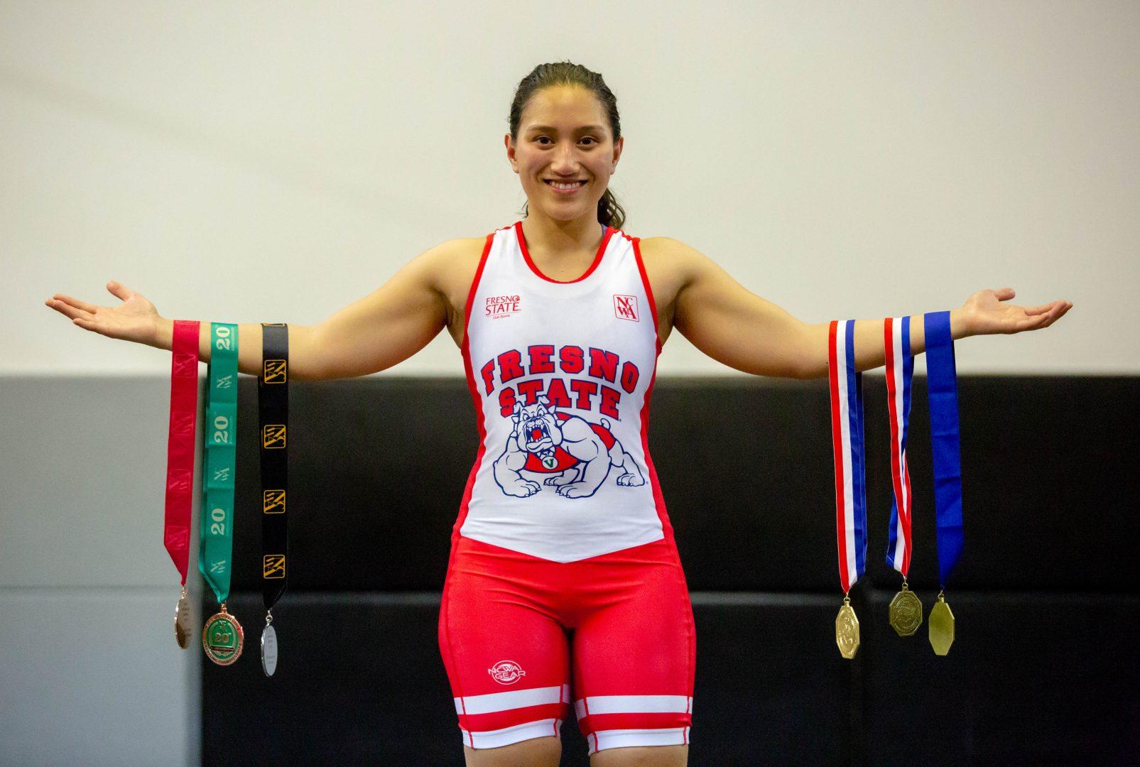Senior Rossana Aguilar showing off the medals received during her illustrious career at Fresno State. (Jose Romo Jr./ The Collegian)