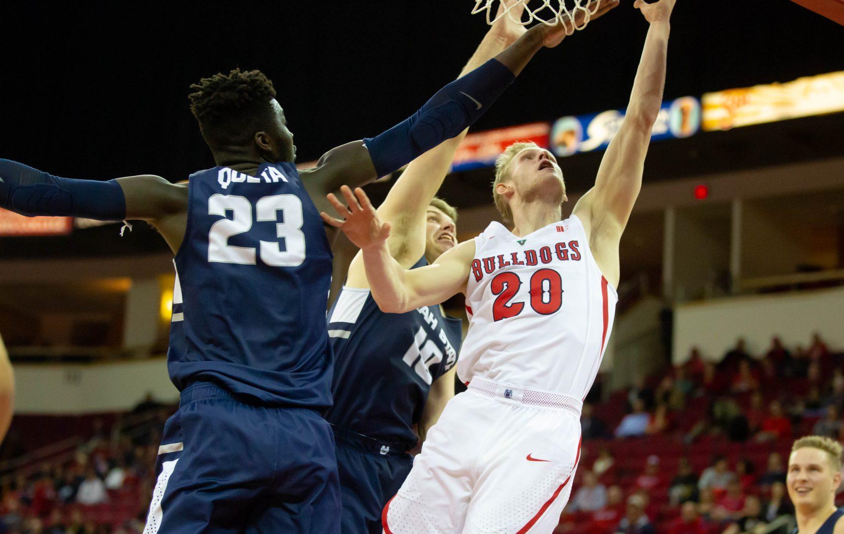 Fresno State forward Sam Bittner attempts a layup while defended by Utah State’s
Neemias Queta, left, and Quinn Taylor during the Bulldogs’ 82-81 loss at the Save Mart Center
on Feb. 5, 2019. (Jose Romo Jr./The Collegian).