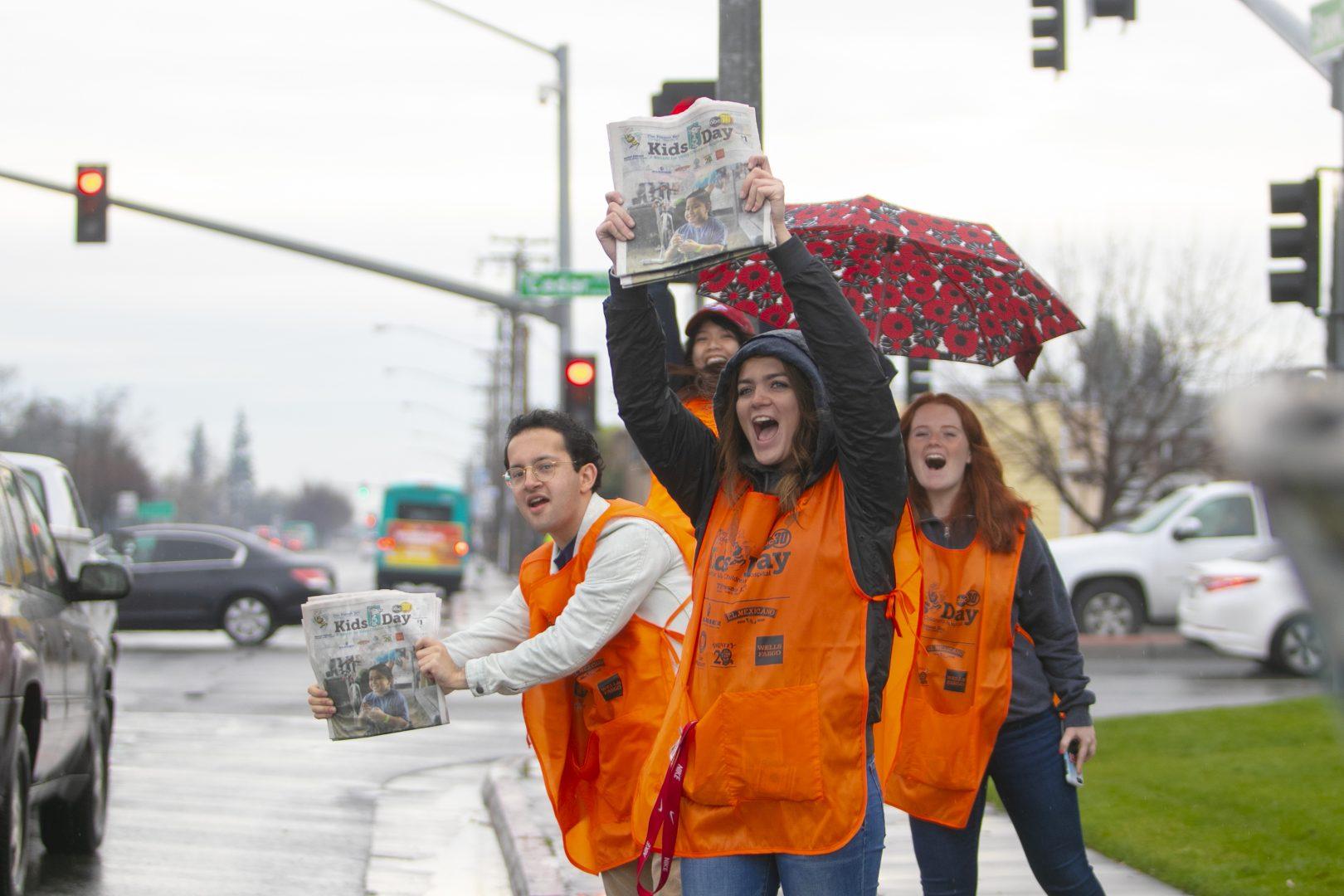 Fresno State student Isabella Medina hands out Kids Day papers with her sociology club at the corner of Barton and Shaw Avenues on Tuesday, March 5, 2019. (Larry Valenzuela/ The Collegian)