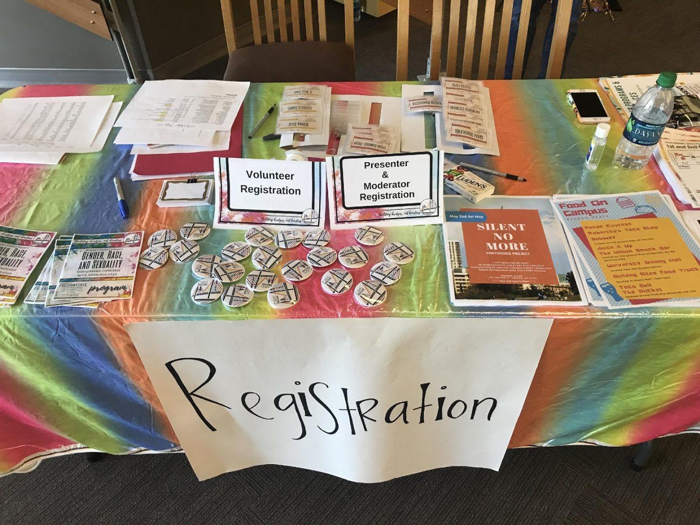 The main booth of the “Gender, Race, and Sexuality” conference featured pins and pamphlets with information about every panel.   (Vanessa Rios/ The Collegian)