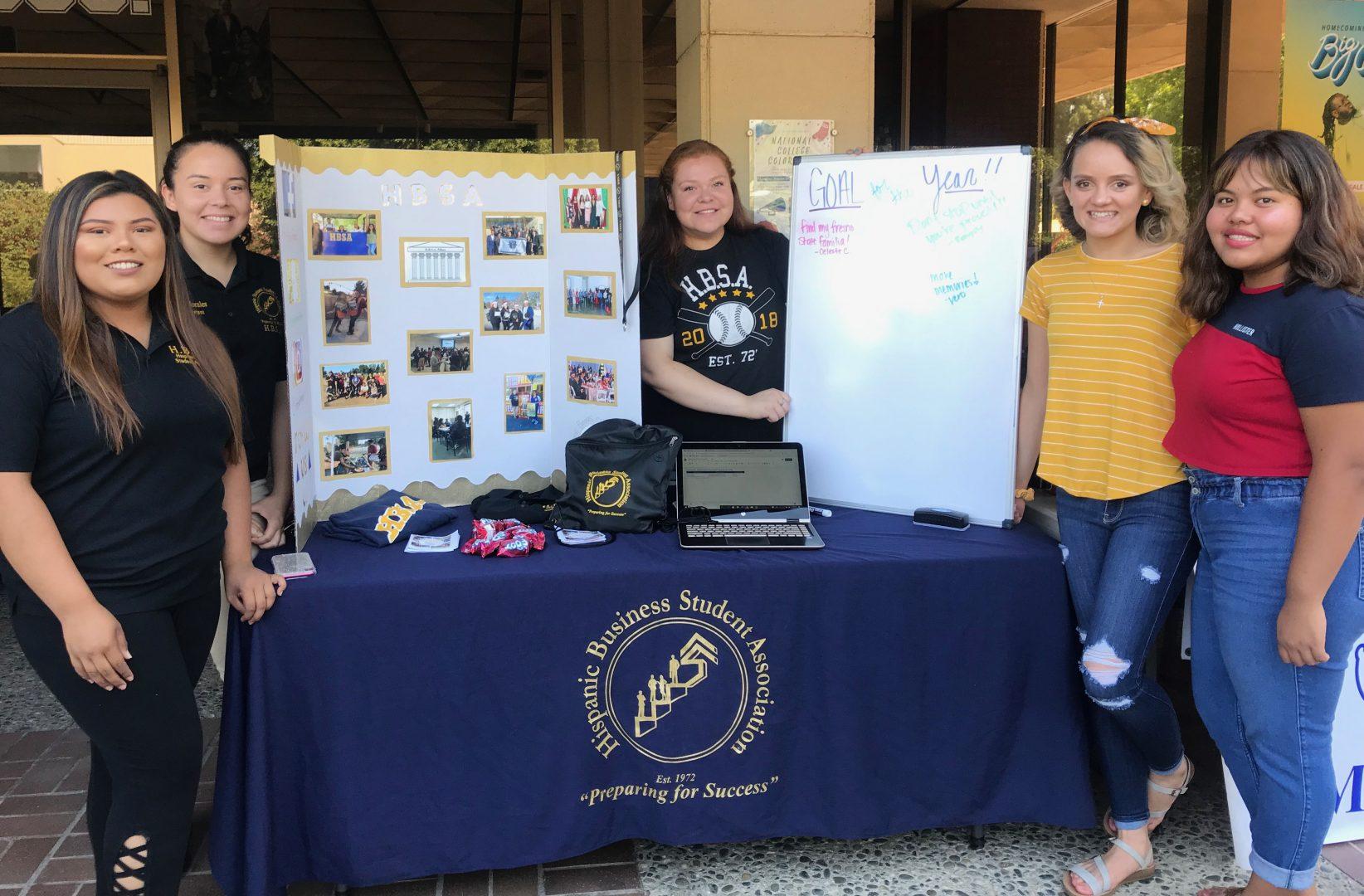 (From left to right) President Ivette Palacios, historian Blanca Ramos, webmaster Robejoy Escario and banquet co-chairs Veronica Morales and Celeste Ceballos stand in front of their booth for the Hispanic Business Student Association during Traditions Day at University Student Union’s balcony on Wednesday, Aug. 28, 2019. (Rachel Lewis/The Collegian)