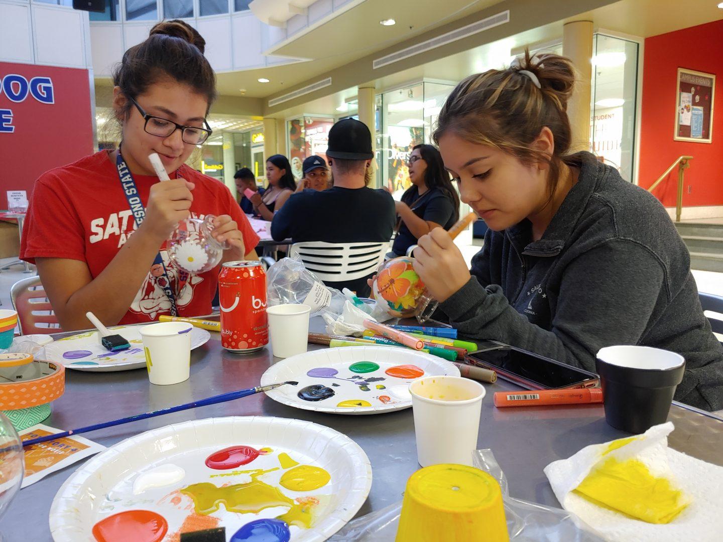 Student participants Jocelyn Ramirez (left) and Jackalene Viranco (right) use various colors of paint as they focus on the details for their designed gumball machines during University Student Union Productions Crafts Night at the lower level of the University Student Union on Tuesday, Sept. 10, 2019. (Jennifer Reyes/The Collegian)