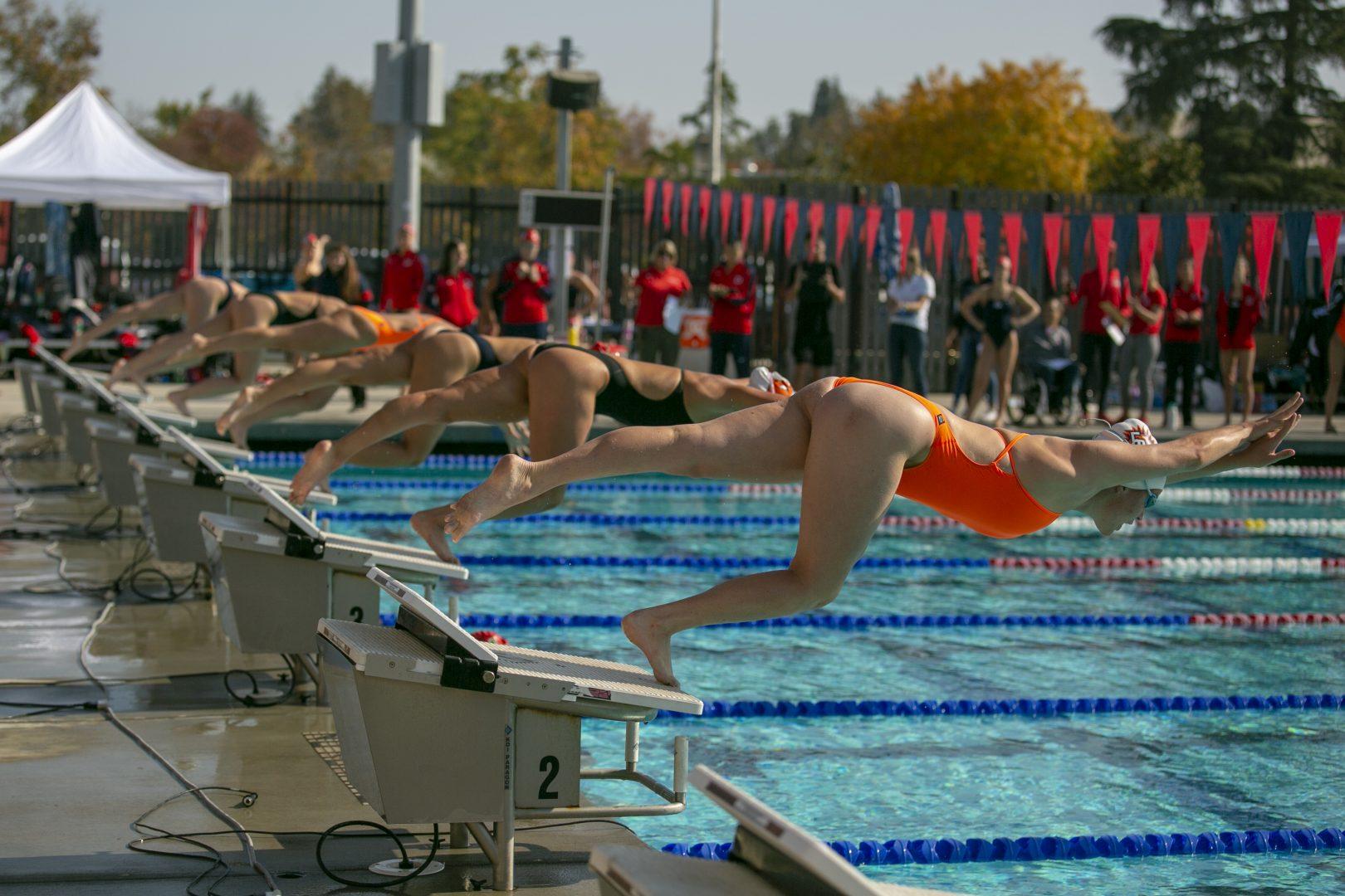 Swimmers dive into the pool during a competition at the Fresno State Aquatic Center on Saturday, Nov. 16 2019.