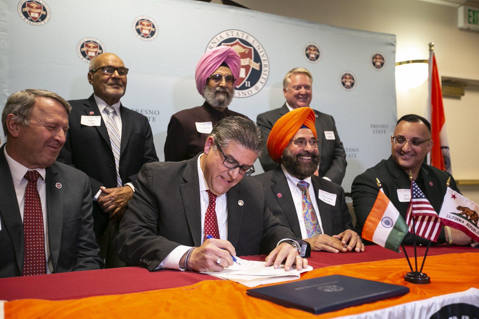 Top from left to right: Dr. Arjan Josan, Parshaura Dhillon and Dr. Scott Moore and bottom from left to right: Dr. Dennis Nef, Dr. Joseph I. Castro, Choranjit Batth and Dr. Gary Chahil sign an agreement to formalize a relationship with Fresno State and Punjab Agriculture University in Ludhiana, India, in an effort to share research and learn from each other in common areas of agricultural issues in the Smittcamp Alumni House on Tuesday, Nov. 12, 2019. (Larry Valenzuela/ The Collegian)