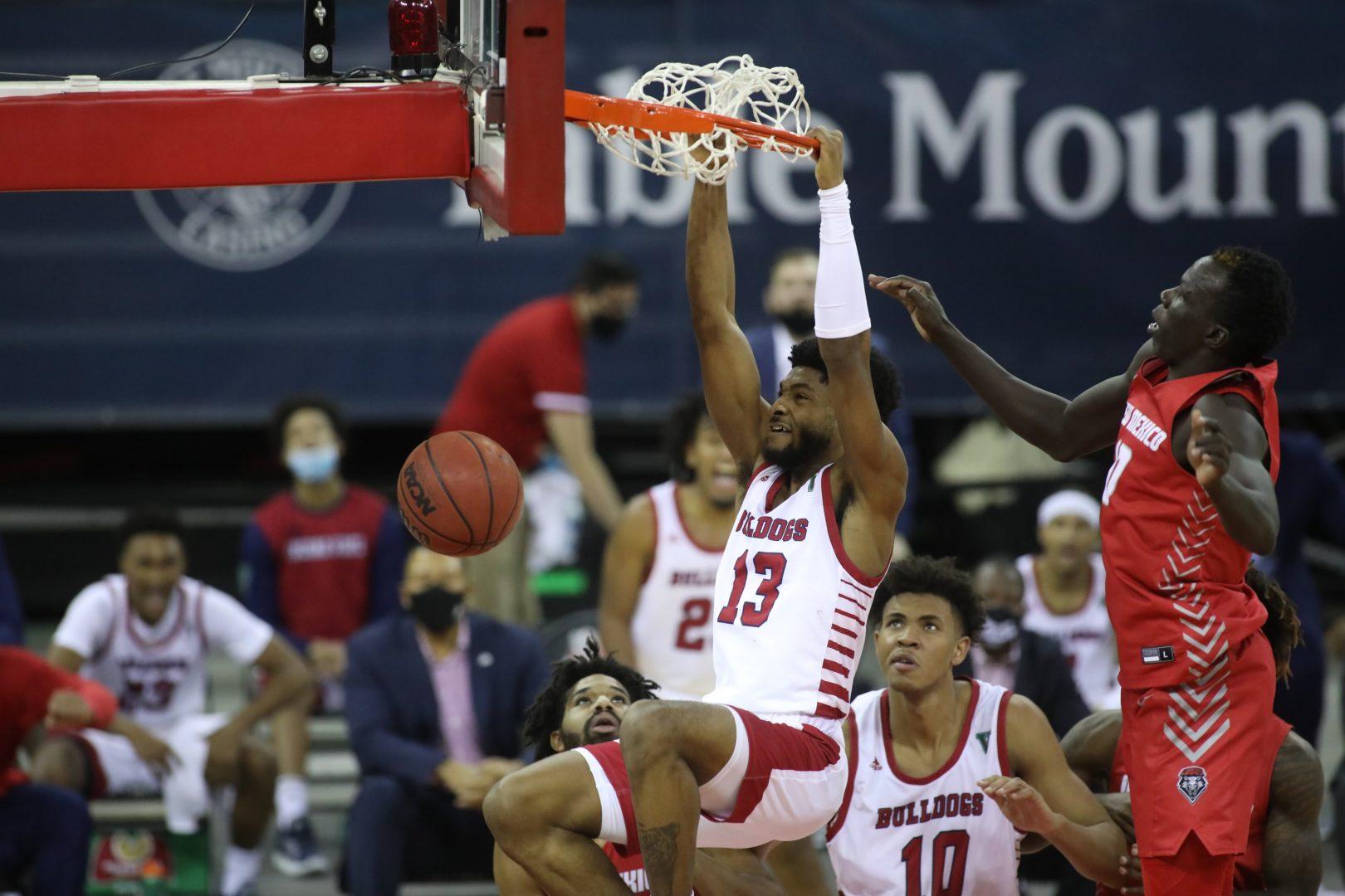 Deon Stroud hangs on the rim after a two-handed dunk. (Sam Marshall/Fresno State Athletics)