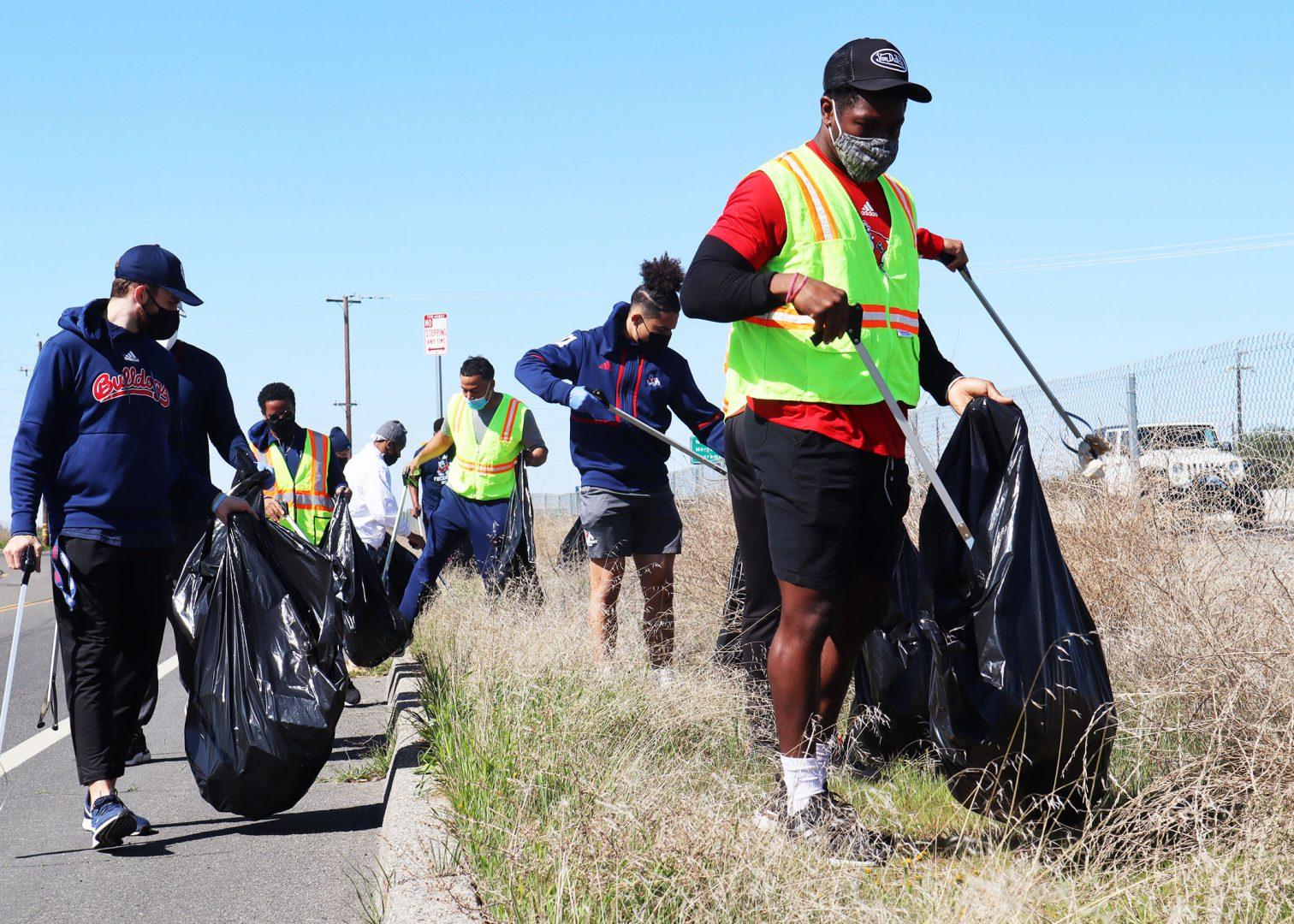 Fresno State football players pick up waste along Island Waterpark Drive on Saturday, Feb. 27, 2021. (Kameron Thorn/The Collegian)