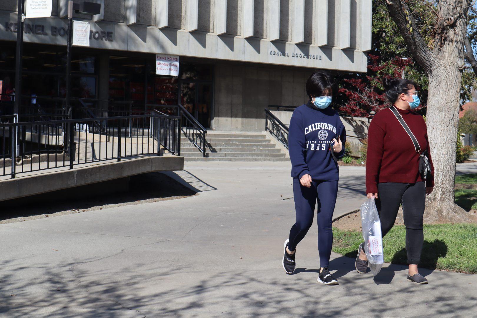 Two Fresno State students leave the Kennel Bookstore on March 23, 2021, at Fresno State. (Kameron Thorn / The Collegian)