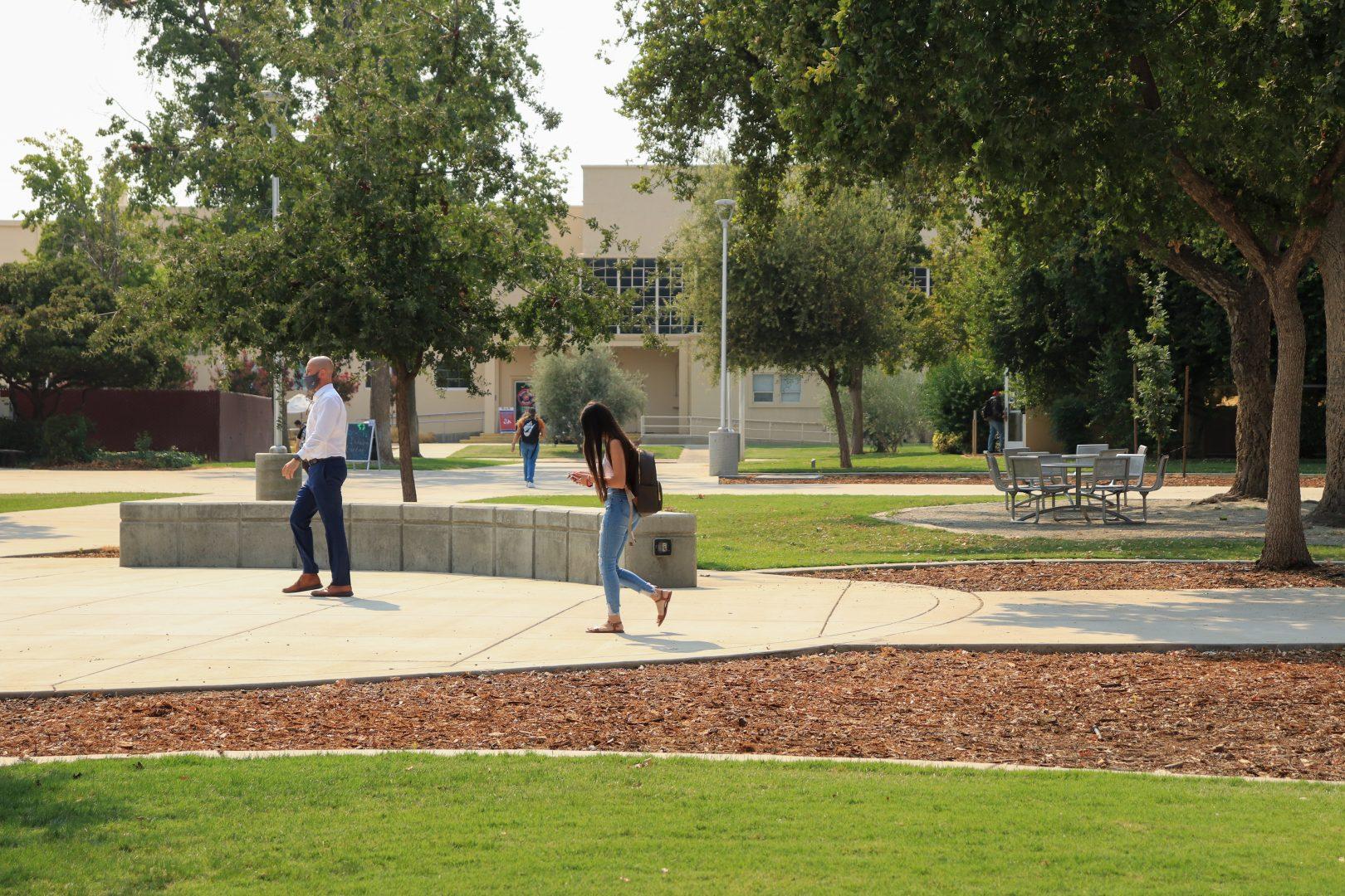 Students and faculty walk across campus as in-person classes continue at Fresno State. (Melina Kazanjian/The Collegian)