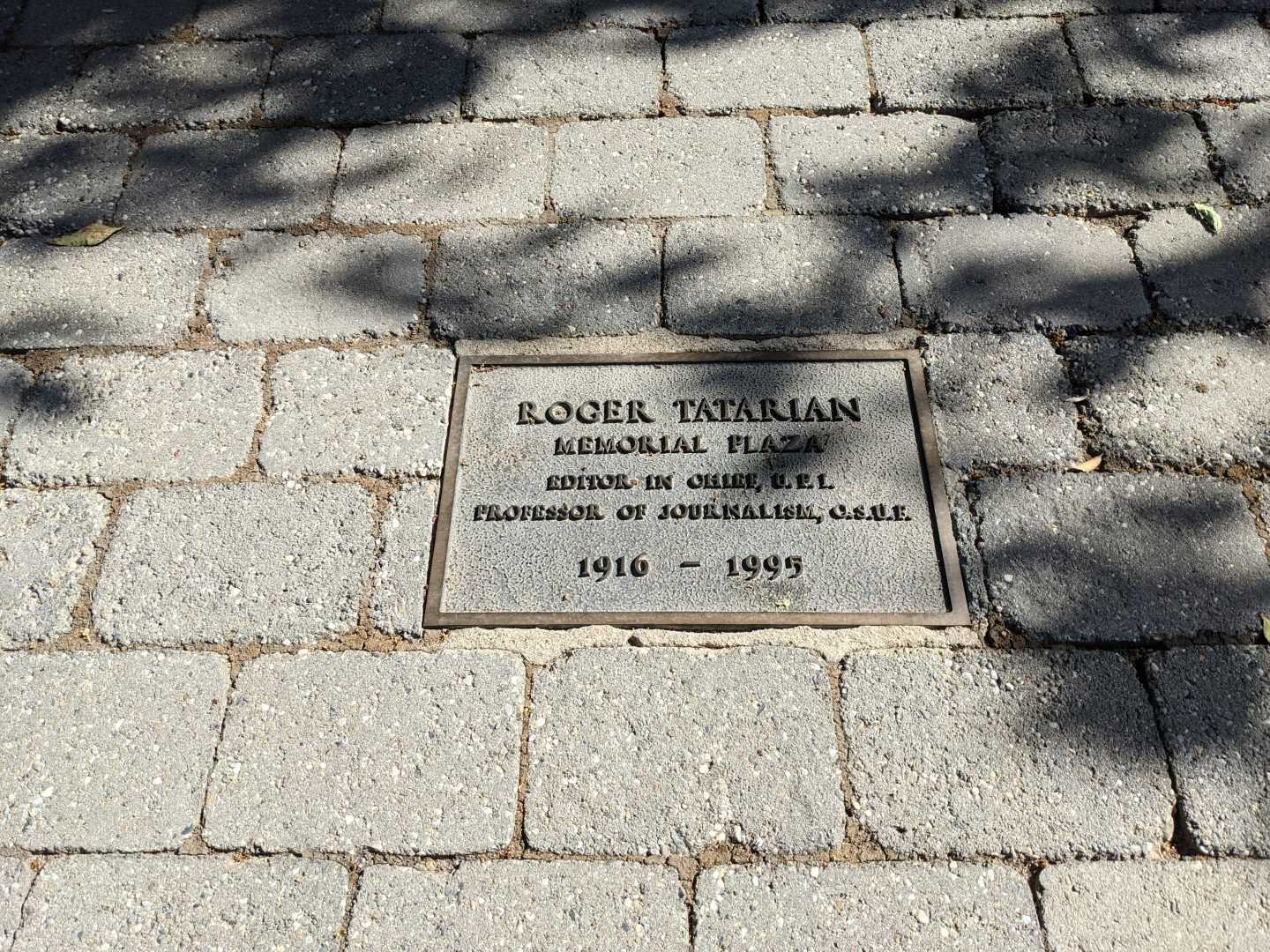 A memorial plaque is located on the ground in the Roger Tatarian Memorial Plaza at Fresno State outside of the McKee Fisk building. (Zaeem Shaikh/The Collegian)