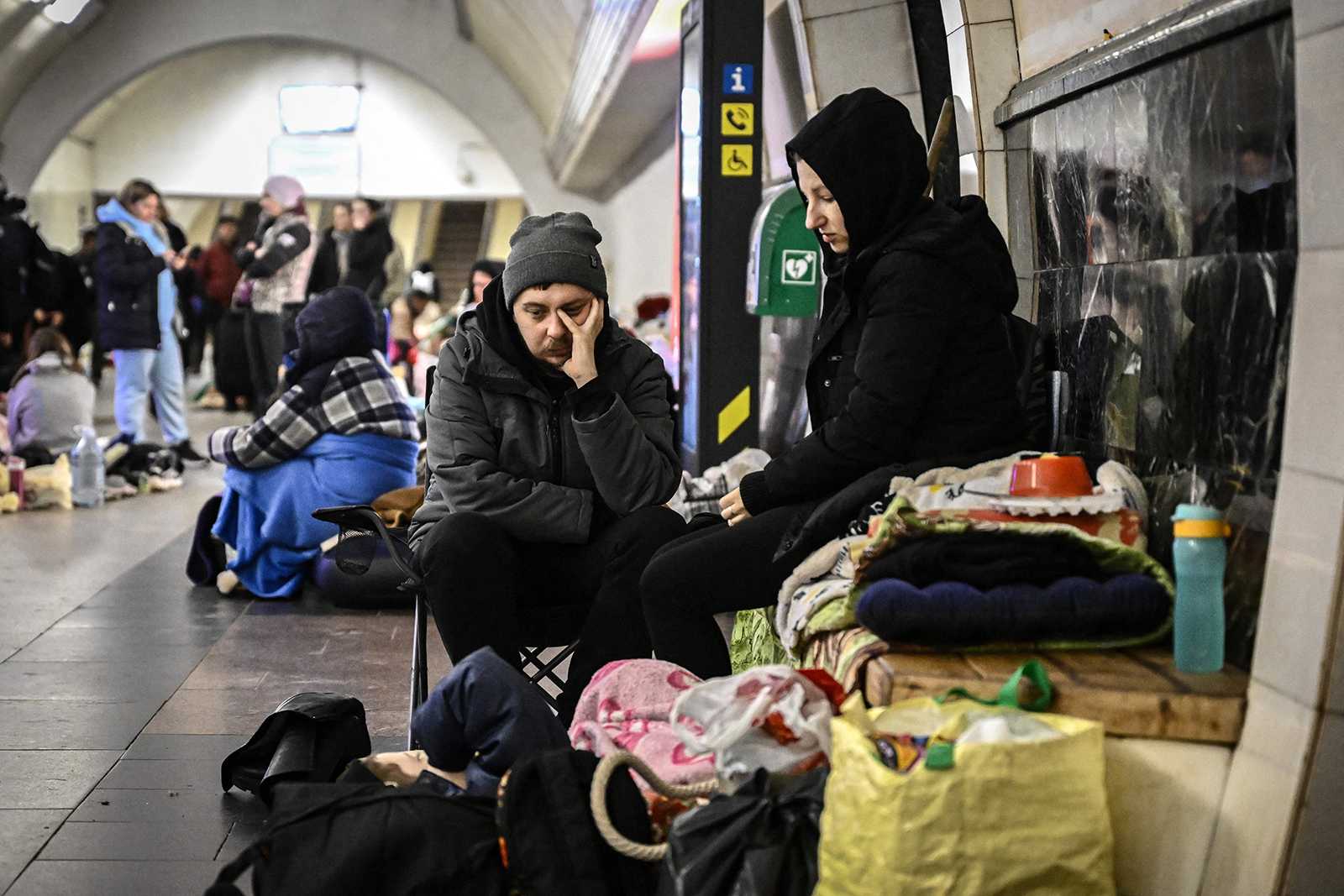 A couple sits in an underground metro station used as bomb shelter in Kyiv on March 2, 2022. - On the seventh day of fighting in Ukraine Russia claims control on March 2, 2022, of the southern port city of Kherson, street battles rage in Ukraines second-biggest city Kharkiv, and Kyiv braces for a feared Russian assault. (Aris Messinis/STF/AFP via Getty Images/TNS)