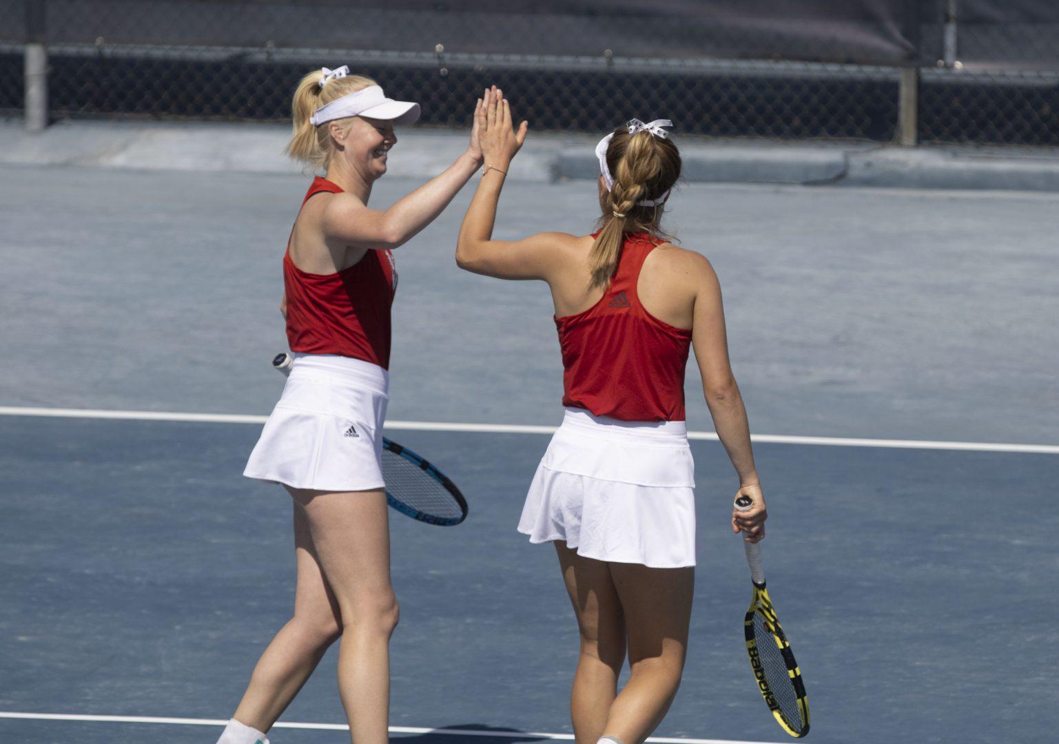 Jane Ellis and A.C. Hummel celebrate a point for their doubles match against Fresno Pacific March 18, 2022 at Spalding G. Wathen Tennis Center. (Anahi Jaramillo / The Collegian)