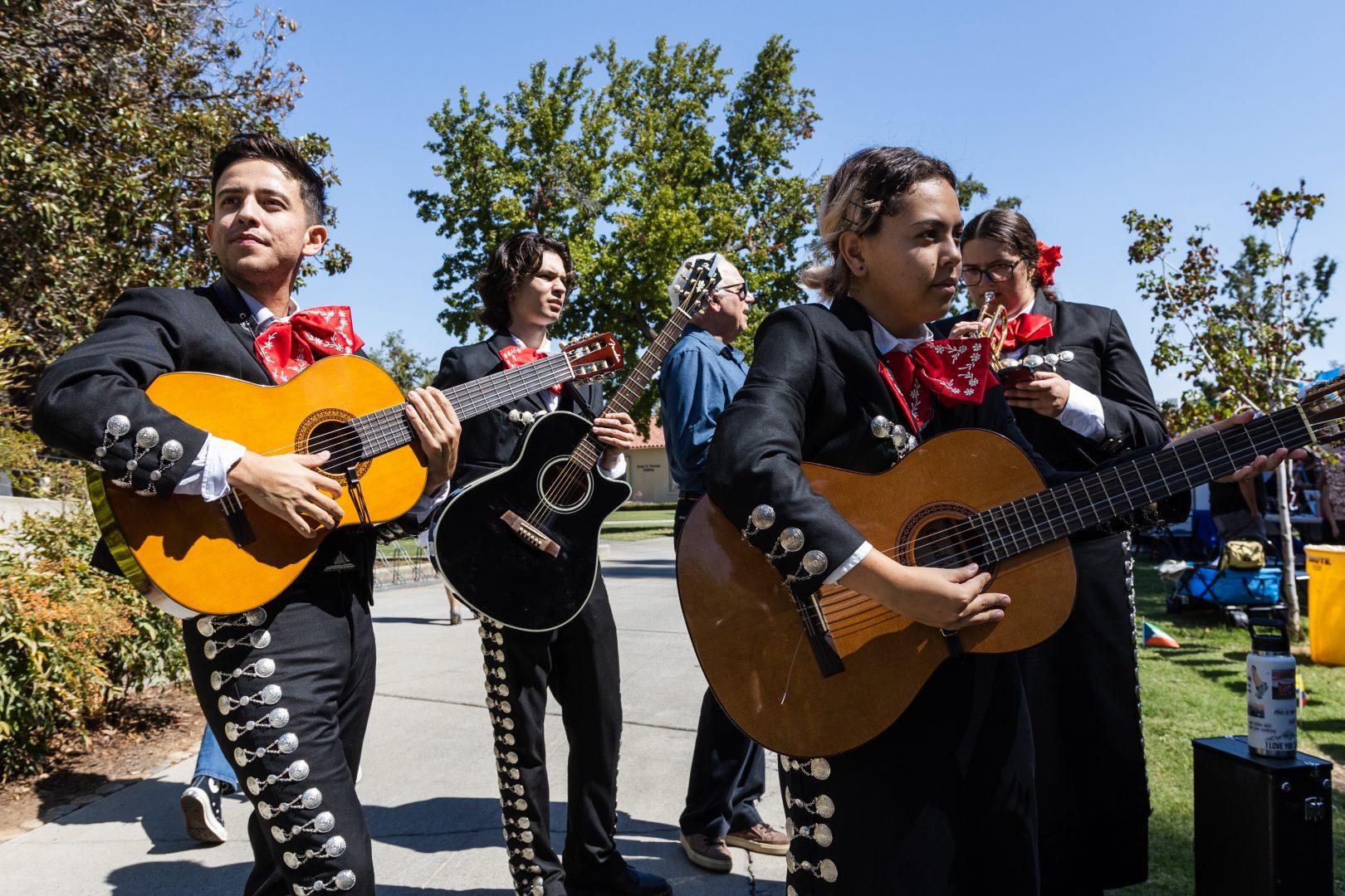 Fresno States Mariachi Orgullo guitarist tuning their instruments before their performances at the Bienvenida in front of the Kennel Bookstore on Wednesday, September 21, 2022. (Carlos Rene Castro/The Collegian)