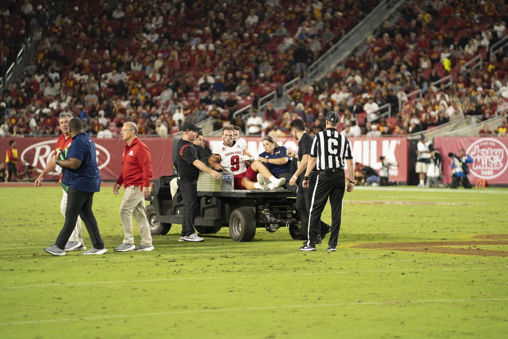 Jake Haener is carried out after suffering a high-ankle sprain in the third quarter of the game against USC. (Blake Wolf/ The Collegian)