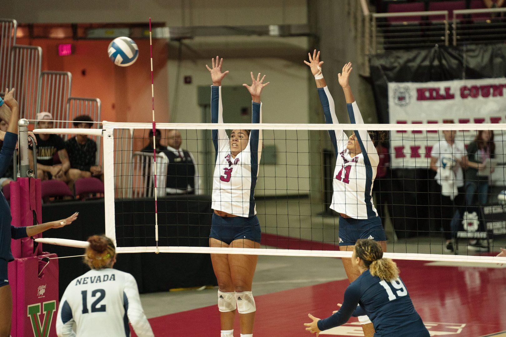 Preslee Lillard and Kasey Purry jump up to block a spike from Nevada in the first Mountain West conference game of the season at the Save Mart Center. (Blake Wolf/ The Collegian)