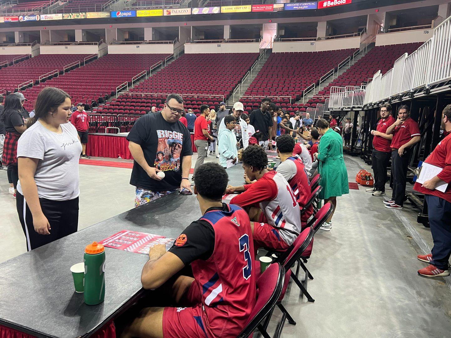 Fresno State mens basketball players sign posters. (Alexis Castellanos/ The Collegian)