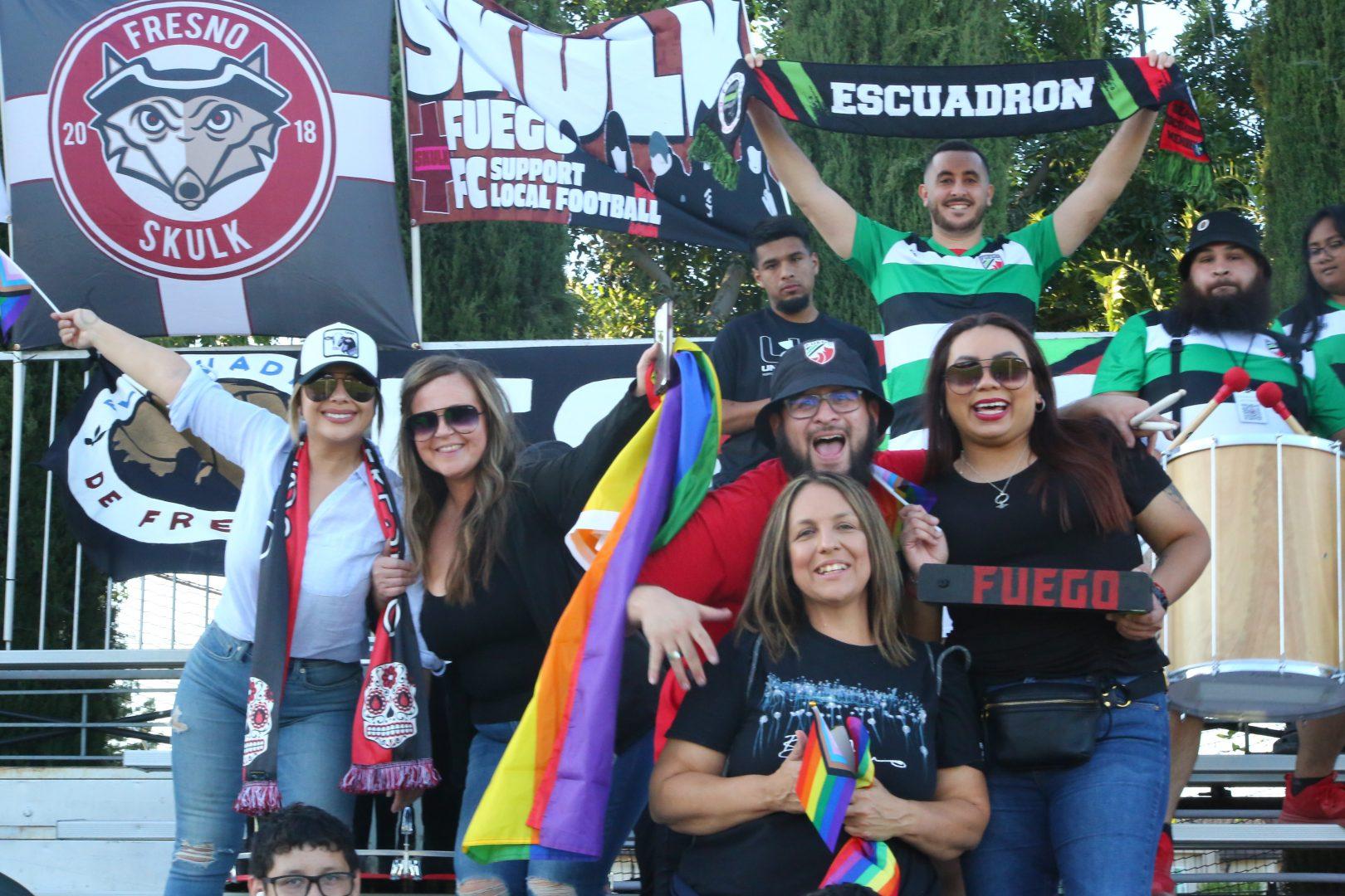 Attendees of the Pride Night game on June 18, 2022, pose for a picture with El EscuadrÃ³n de Fresno (Manuel Hernandez/ The Collegian)
