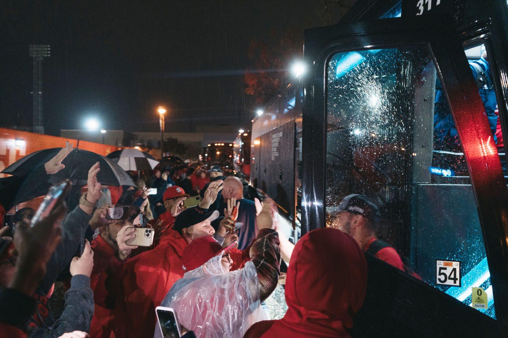 As the rain continued, the fans rushed to the busses to congratulate the team as soon as they stepped out. (Wyatt Bible/ The Collegian)