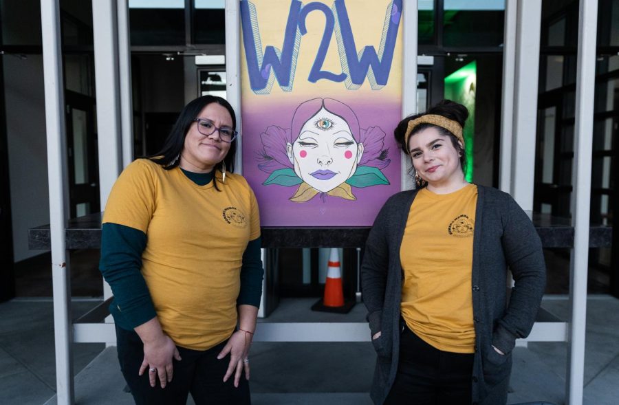 Womxn2Womxn organizers Chelsey Ramirez Hernandez and Sam Lezcano pose together in front of the Womxn2Womxn sign at the Sun Stereo Warehouse in Downtown Fresno on Saturday, January 29, 2023. (Carlos Rene Castro/ The Collegian)