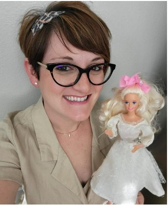 Professor Amila Bercirbegovic holds Barbie in white wedding dress, a toy she played with as a refugee fleeing to Germany.