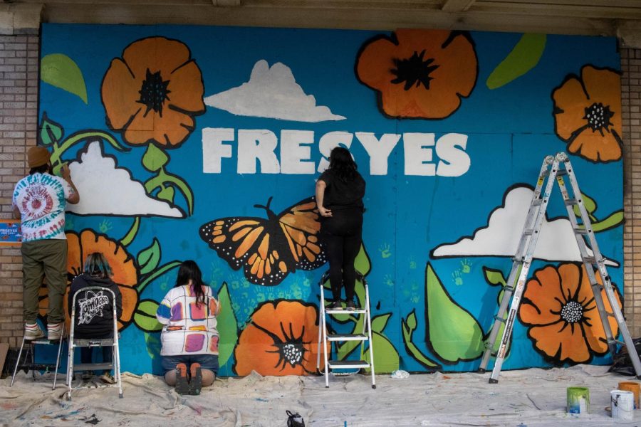 Local artists Joseph Rodriguez (left), artist Gooey Stranger (middle), and Sarah Joy (right) paint FresYes mural. (Sarah Delgado/The Collegian)