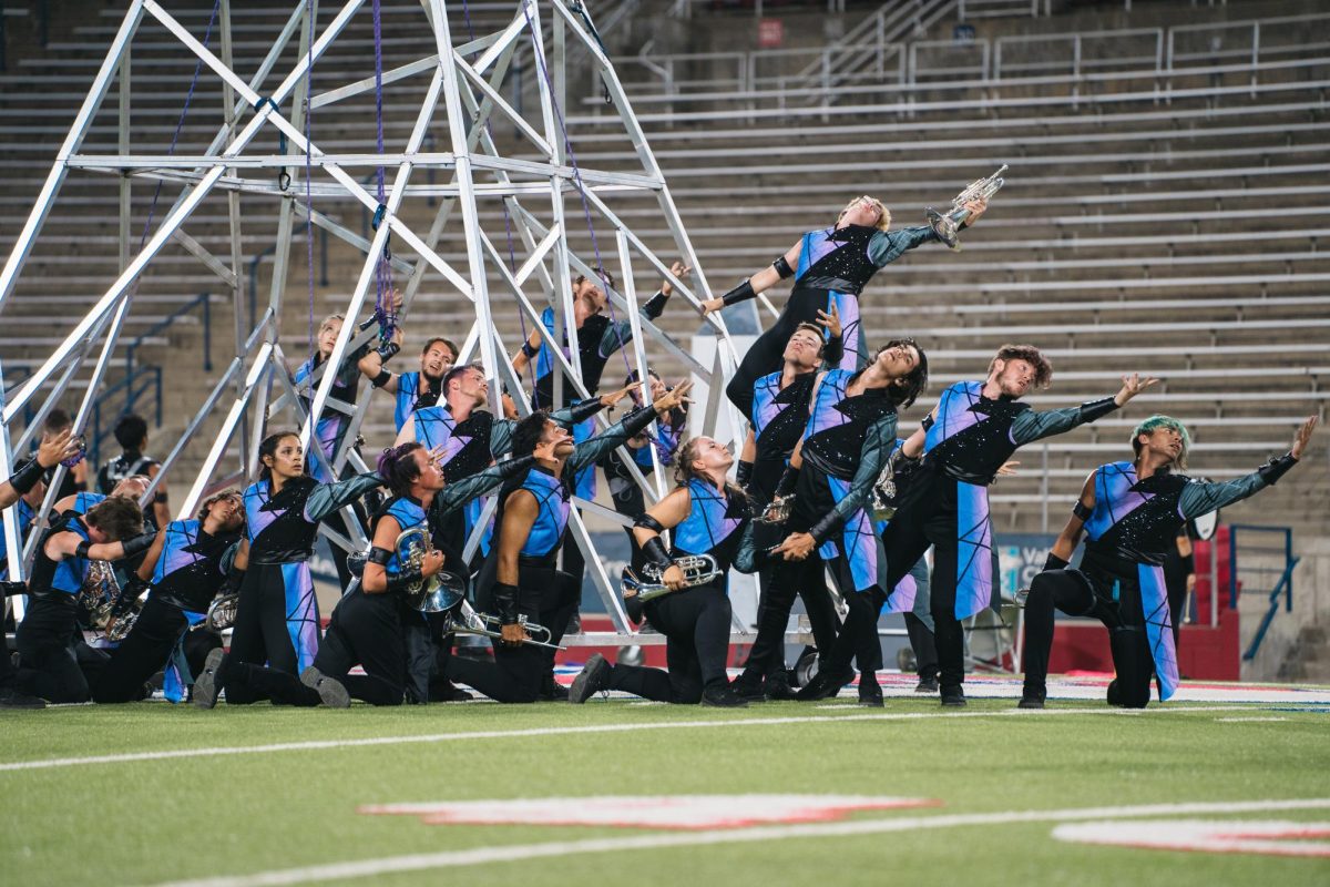 Bulldog Marching Band member Zachary Gifford (left behind) performs choreography with the Blue Knights during their show titled Unharnessed.