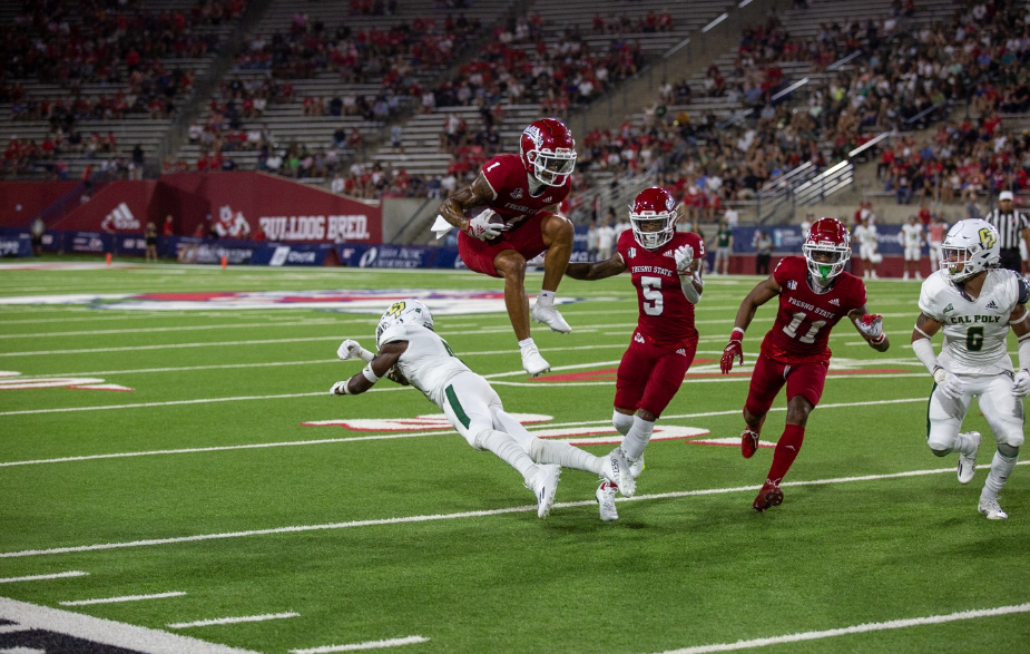 Nikko Remigio jumps over a Cal Poly player during the 2022 football season. 