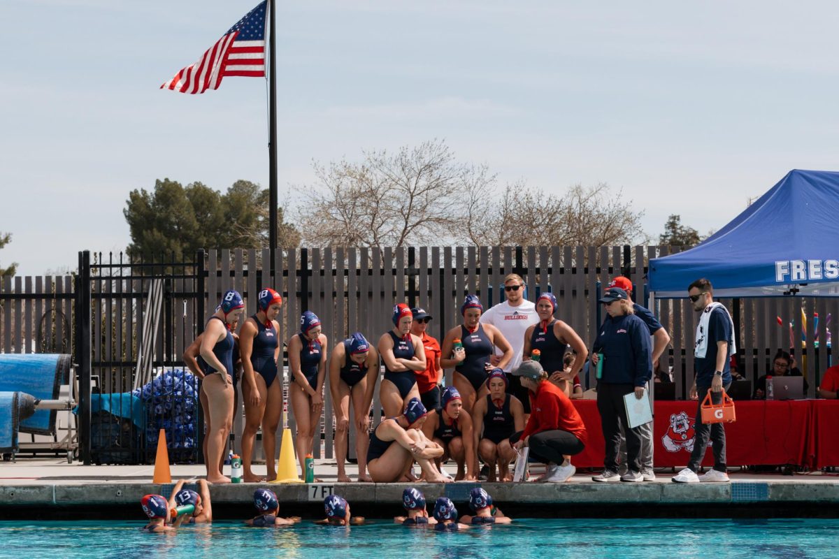 The Fresno State water polo team gathers together during the game at the Aquatics Center on March 18, 2023. 