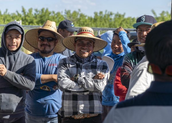 Farm workers laugh amongst each other as prizes are called out during the Heart of the USA philanthropy event hosted by Beta Gamma Nu Fraternity Inc.
