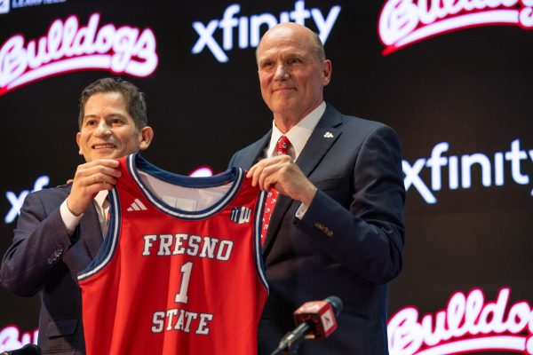 Fresno State President Saúl Jiménez-Sandoval and mens basketball Head Coach Vance Walberg hold up basketball jersey on April 12.