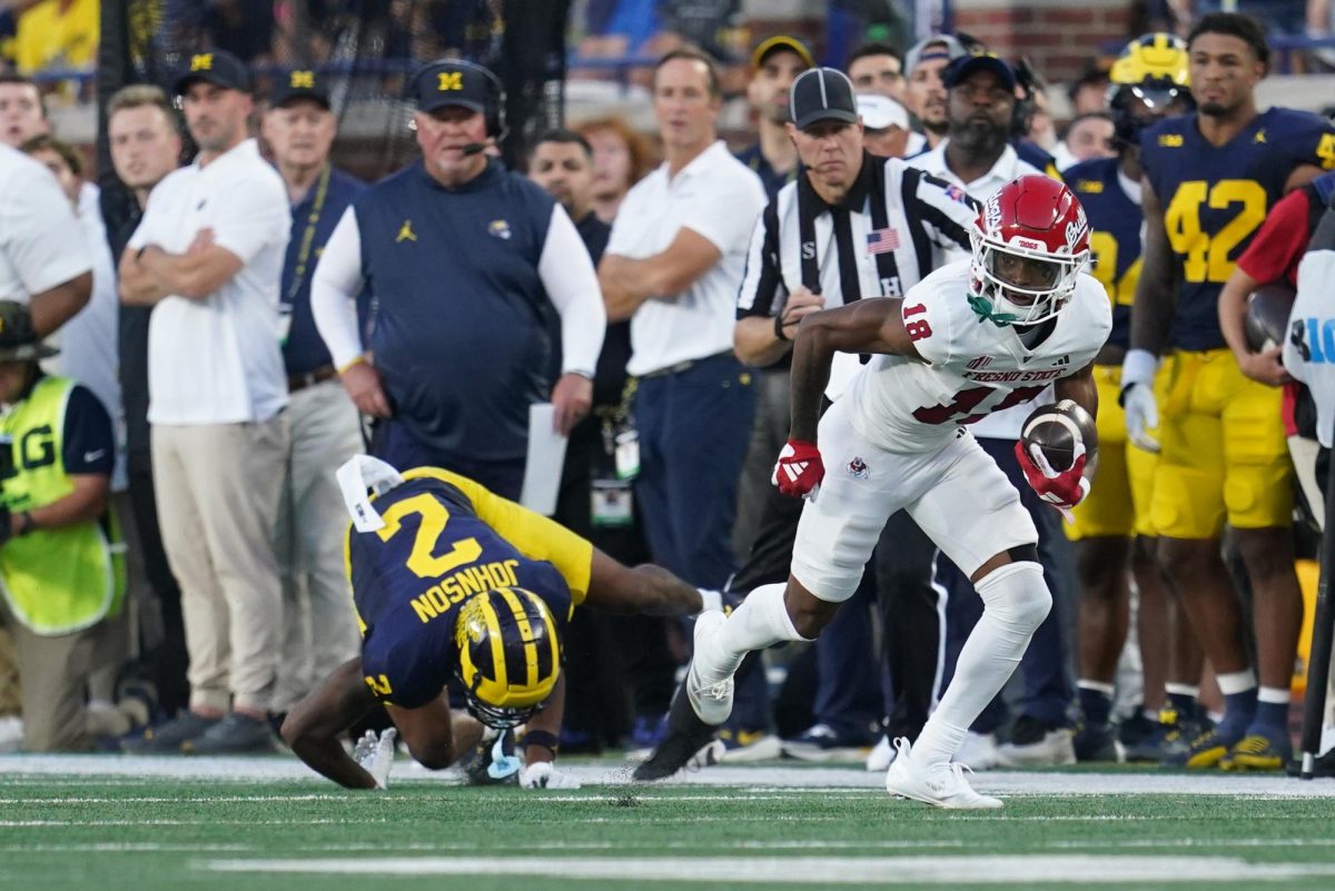 Jalen Moss running down the sideline after acrobatic catch. 