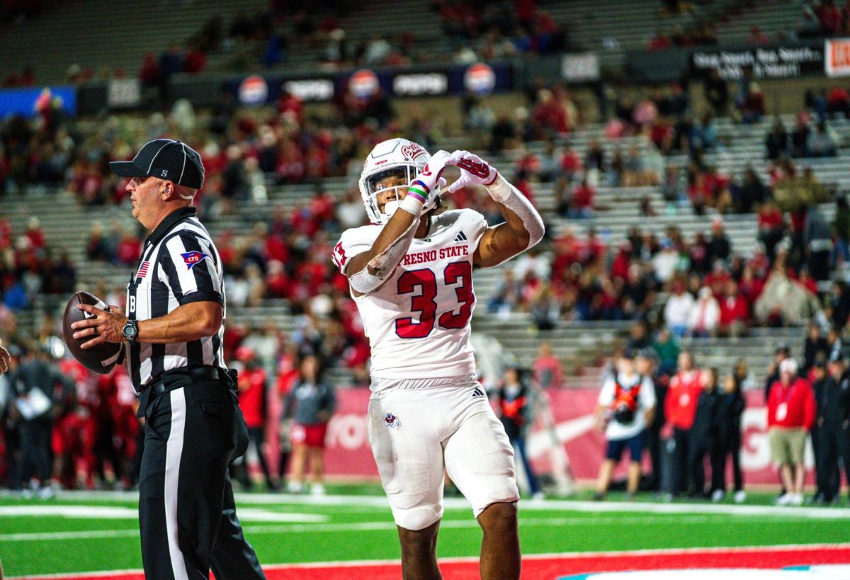 Running back Elijah Gilliam (33) holds his hands in the shape of a heart after rushing for a late touchdown. 