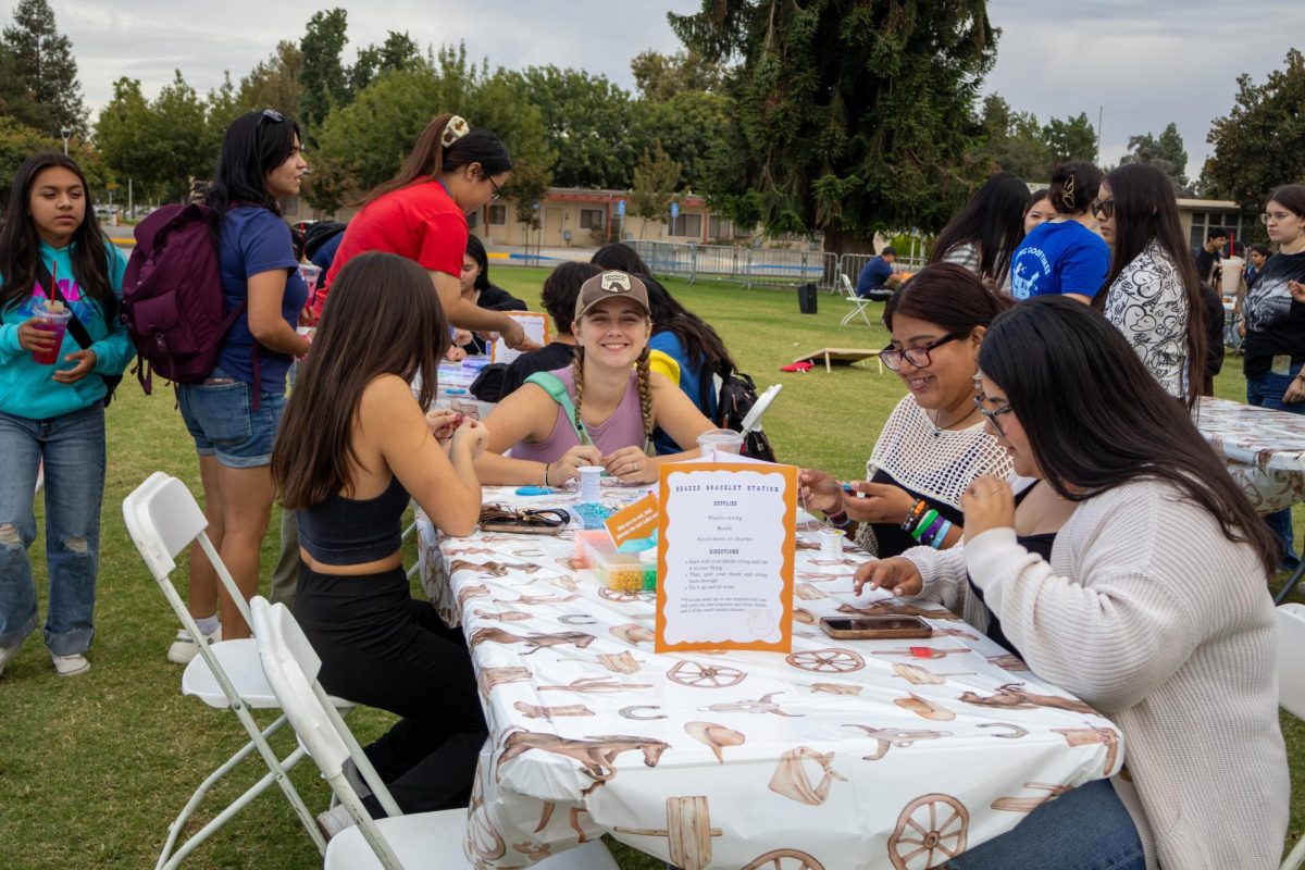 Students make bracelets at the 'beaded bracelet station' at Bulldog Roundup, Fresno State's first Spotlight Events event on the south lawn of the Resnick Student Union on Sept. 18. 