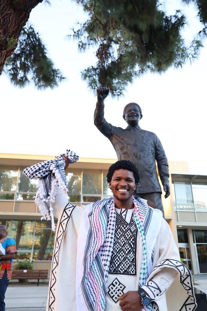 Siyabulela poses with the statue of his great-grandfather, Nelson Mandela. The statue was unveiled at Fresno State on Sept. 12 in the Peace Garden.