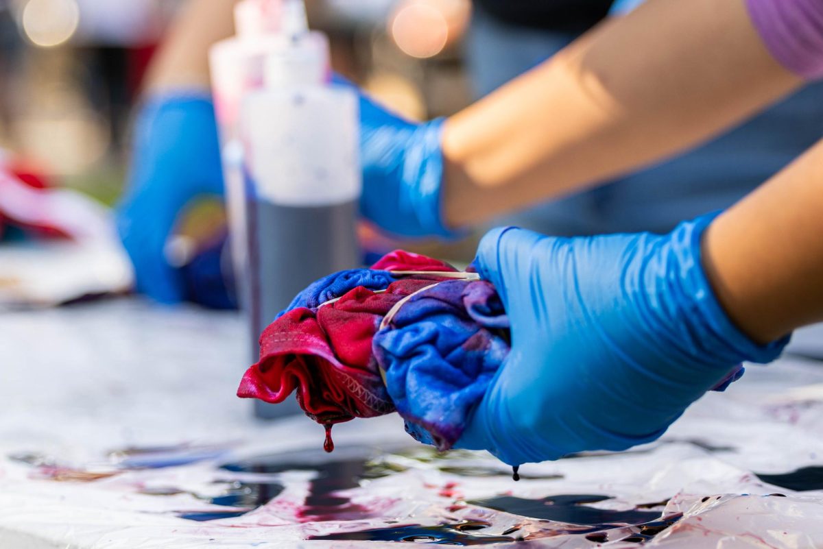 Fresno State students tie dye t-shirts as part of the homecoming week festivities on Oct. 24, 2023.