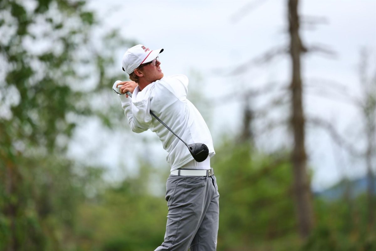 Mason Benbrook watching his ball fly down the green.