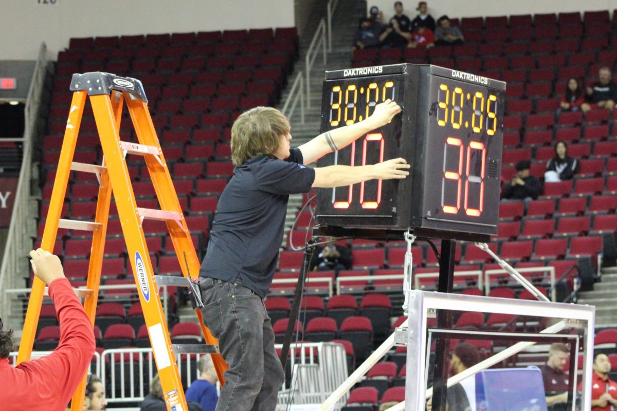 A Save Mart Center employee fixes the shot clock before the game. 