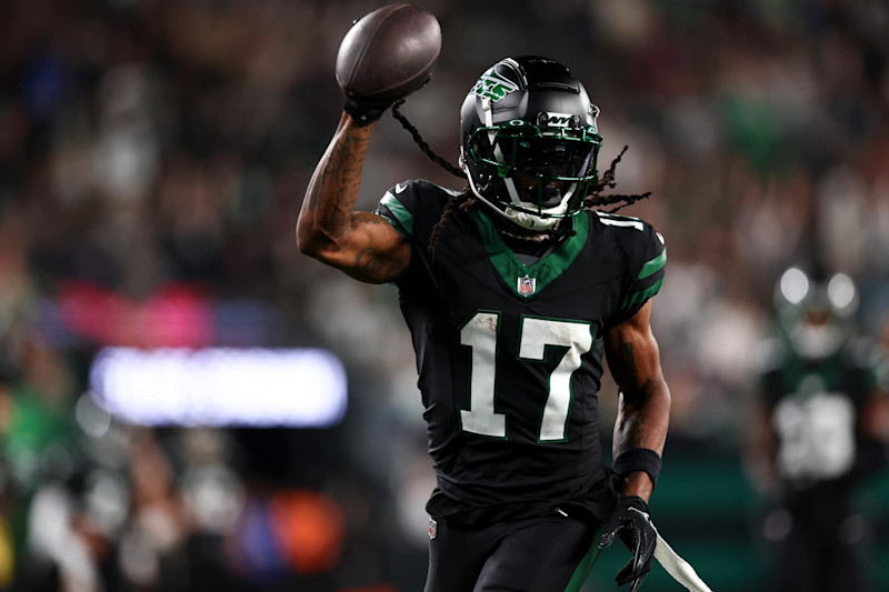 Davante Adams (17) holds up the ball after his first touchdown as a member of the New York Jets at MetLife Stadium on Thursday, October 31, 2024. 