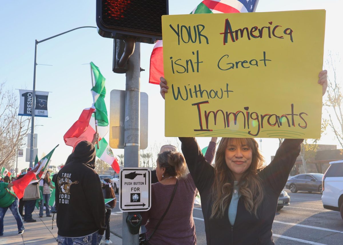 Yarely Torrejon holds up a sign to fight for her belief that immigrants help make America great at a River Park protest for immigration on Jan. 20. 