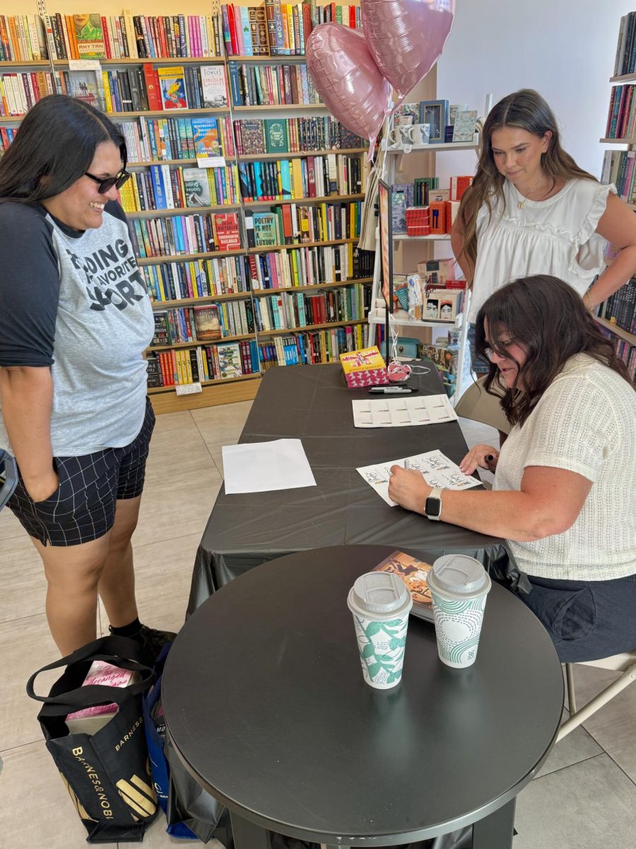 Monica Murphy signs a copy of her latest book for Naila Gonzalez at Fashion Fair's Barnes & Noble location during a book signing on June 3. 