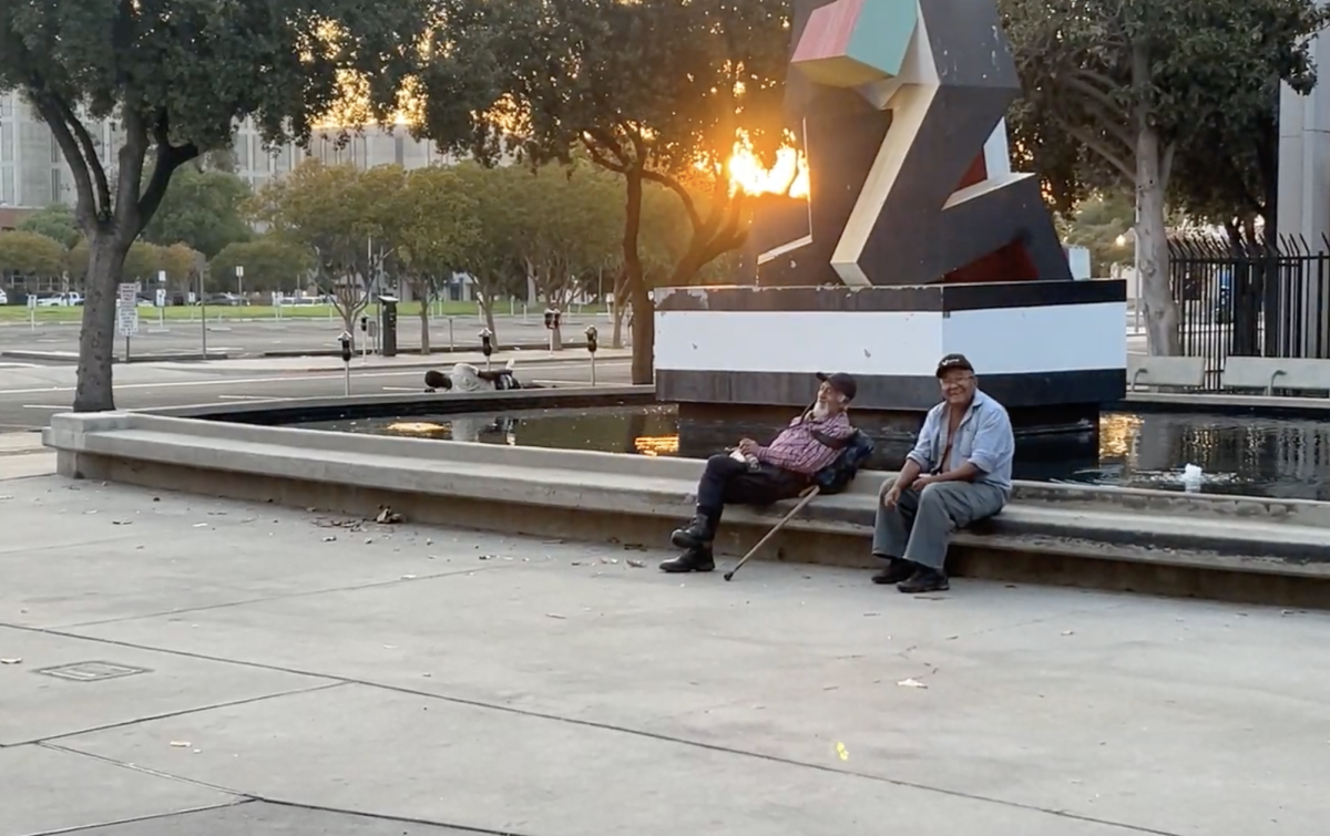 Two men resting outside the Fresno Public Library in Downtown Fresno on Sept. 6.