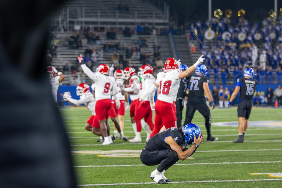 Spartans' quarterback Tama Amisone holds his head in his hands after a Bulldog interception on Nov. 29 at CEFCU Stadium.