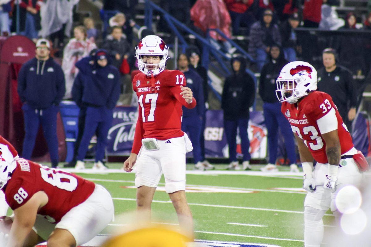 Fresno State quarterback Carson Conklin (17) motions to his receiver while running back Elijah Gilliam (33) stands next to him in the backfield in a game against the Wyoming Cowboys at Valley Children's Stadium on Nov. 15.