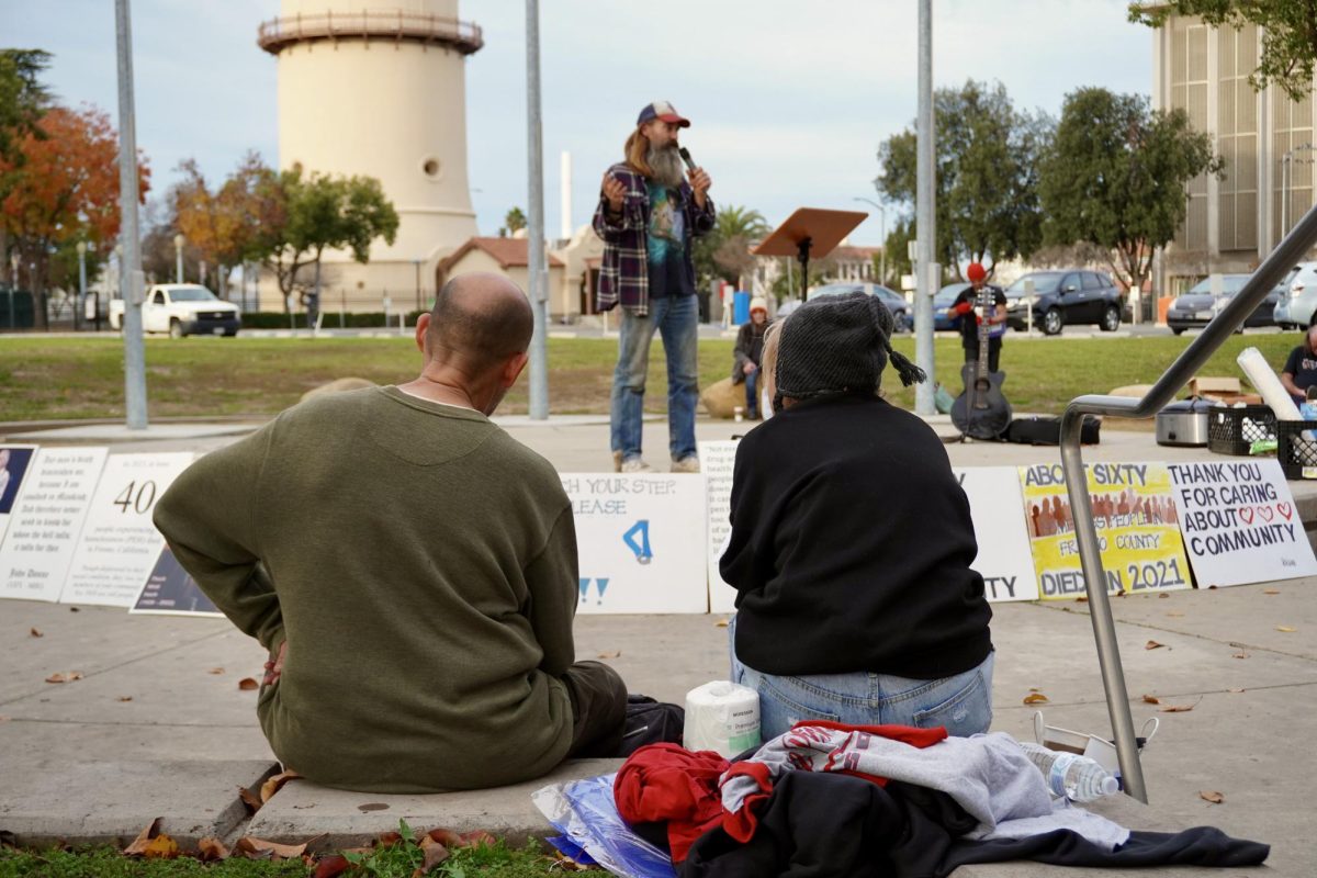 Augustine Osuna and Jasmine Mahenna sit at the Homeless Person's Memorial in Downtown Fresno on Dec. 21.
