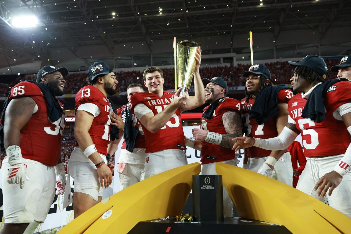 Jan 19, 2026; Miami Gardens, FL, USA; Indiana Hoosiers quarterback Fernando Mendoza (15) reacts with the trophy after the College Football Playoff National Championship game at Hard Rock Stadium. Mandatory Credit: Mark J. Rebilas-Imagn Images