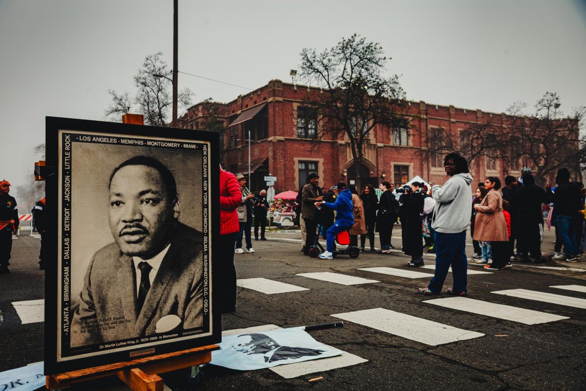 A portrait of Martin Luther King Jr. stands as march participants gather outside Saint John's Cathedral. Jan. 19.